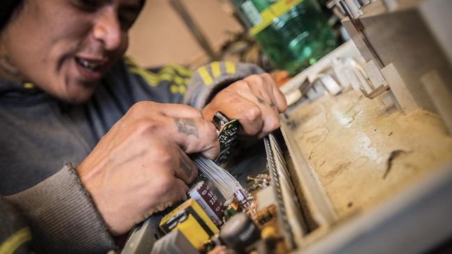 A REEcicla employee in La Paz disassembles e-waste into its individual parts